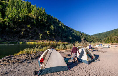 Tents set up along the shore of the Rogue River in Oregon