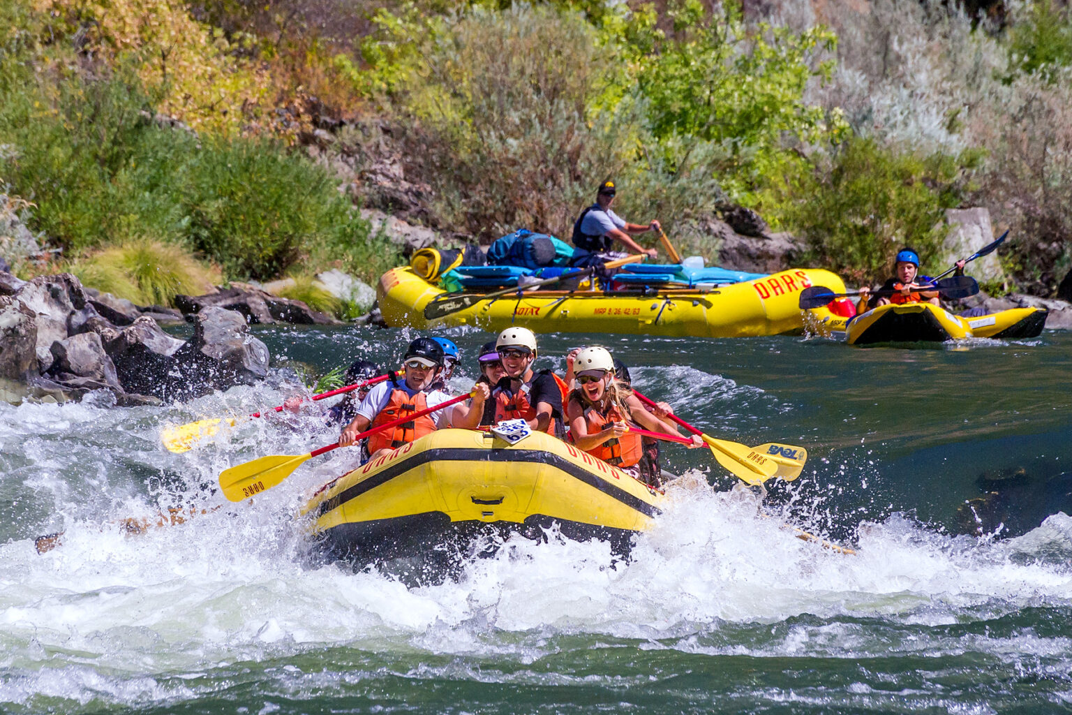 A group of paddler splash through a beginner-friendly rapid on Oregon's Rogue River