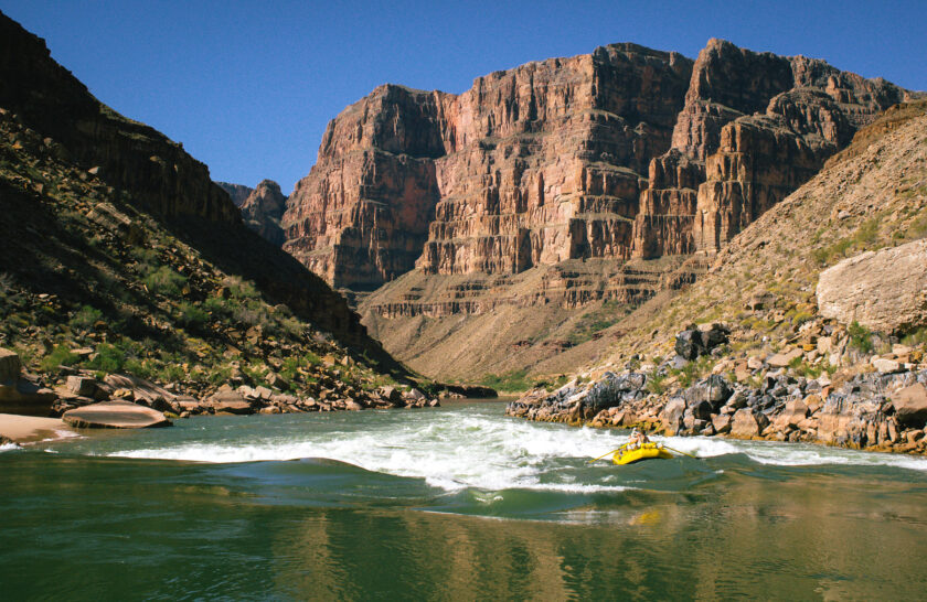 OARS raft navigates Class III rapid in lower section of Grand Canyon