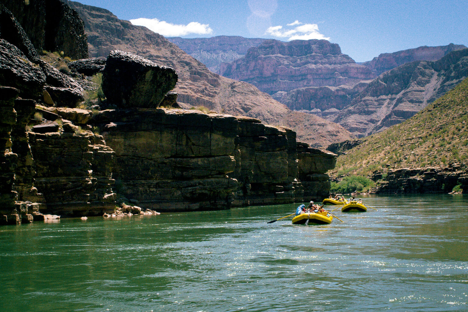 OARS rafts in green water of Colorado River in Grand Canyon