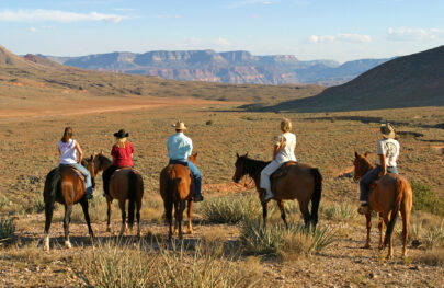 Five guests of OARS and Bar 10 Ranch on horseback look towards Grand Canyon