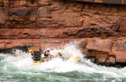 Yellow OARS raft in whitewater in Grand Canyon