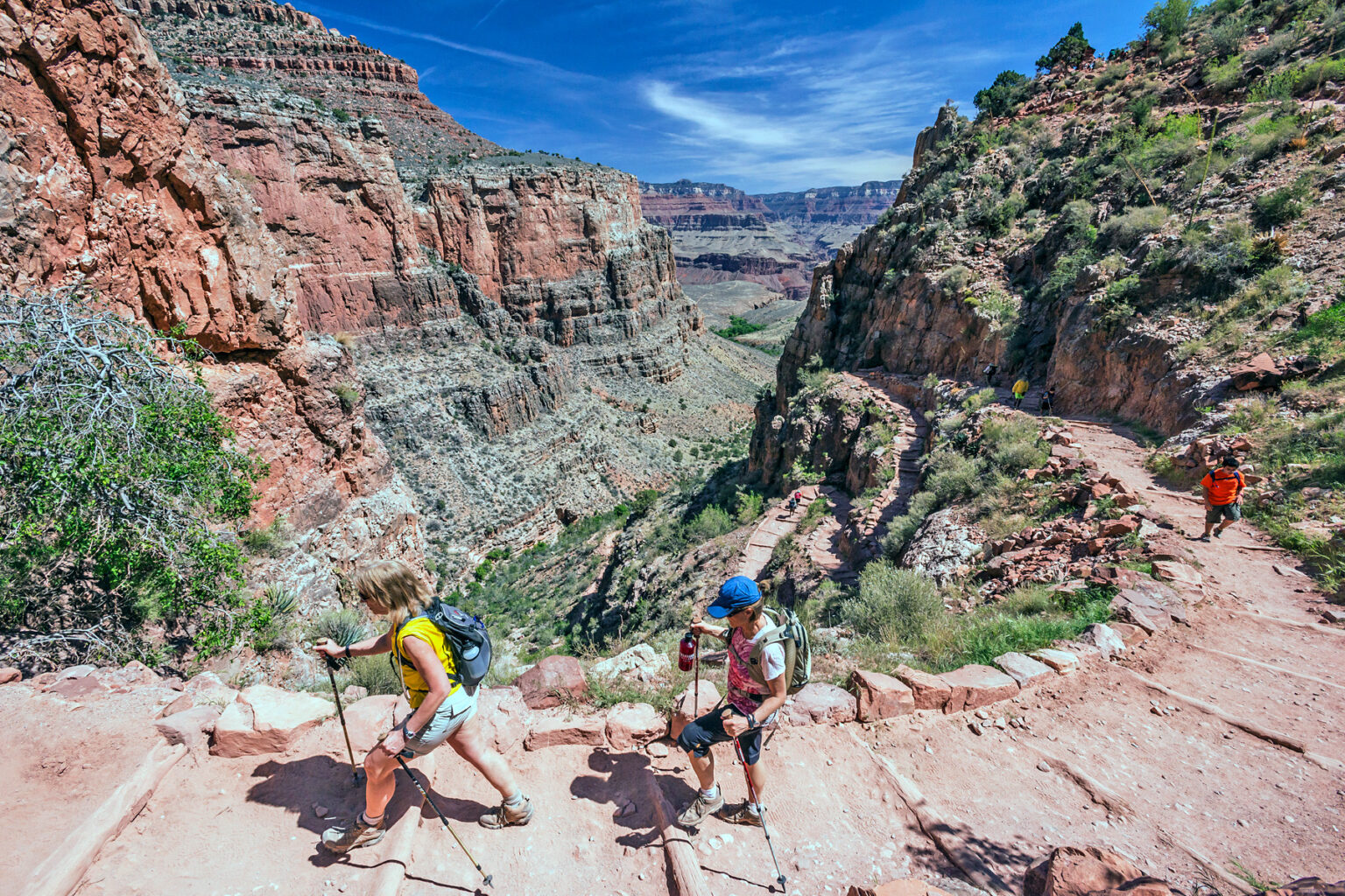 Three hikers ascending Bright Angel Trail in Grand Canyon