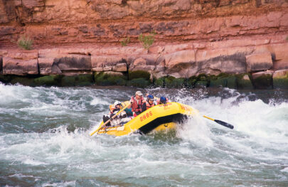 Yellow OARS raft in whitewater in Grand Canyon