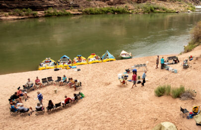 OARS camp from above in Grand Canyon showing moored boats, chair circle, kitchen and tents
