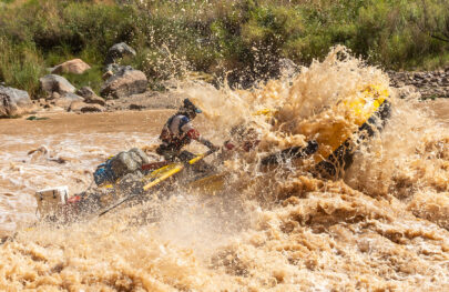 OARS baggage raft hitting a big muddy rapid in Grand Canyon