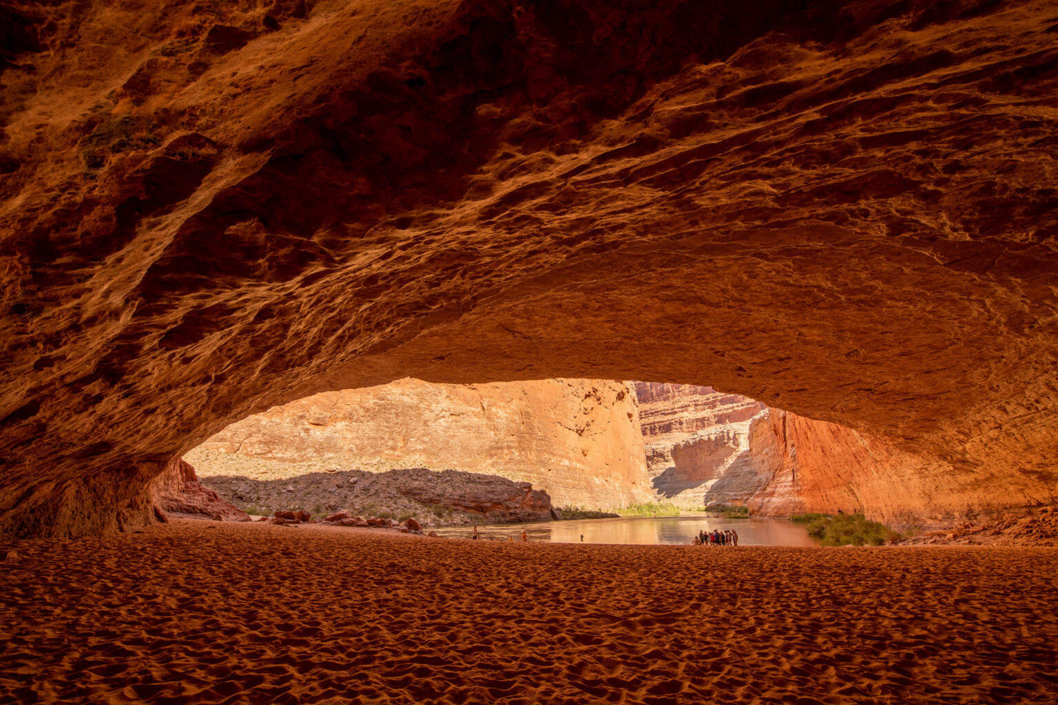 Redwall Cavern from the back looking out towards a group of guides and guests in Grand Canyon