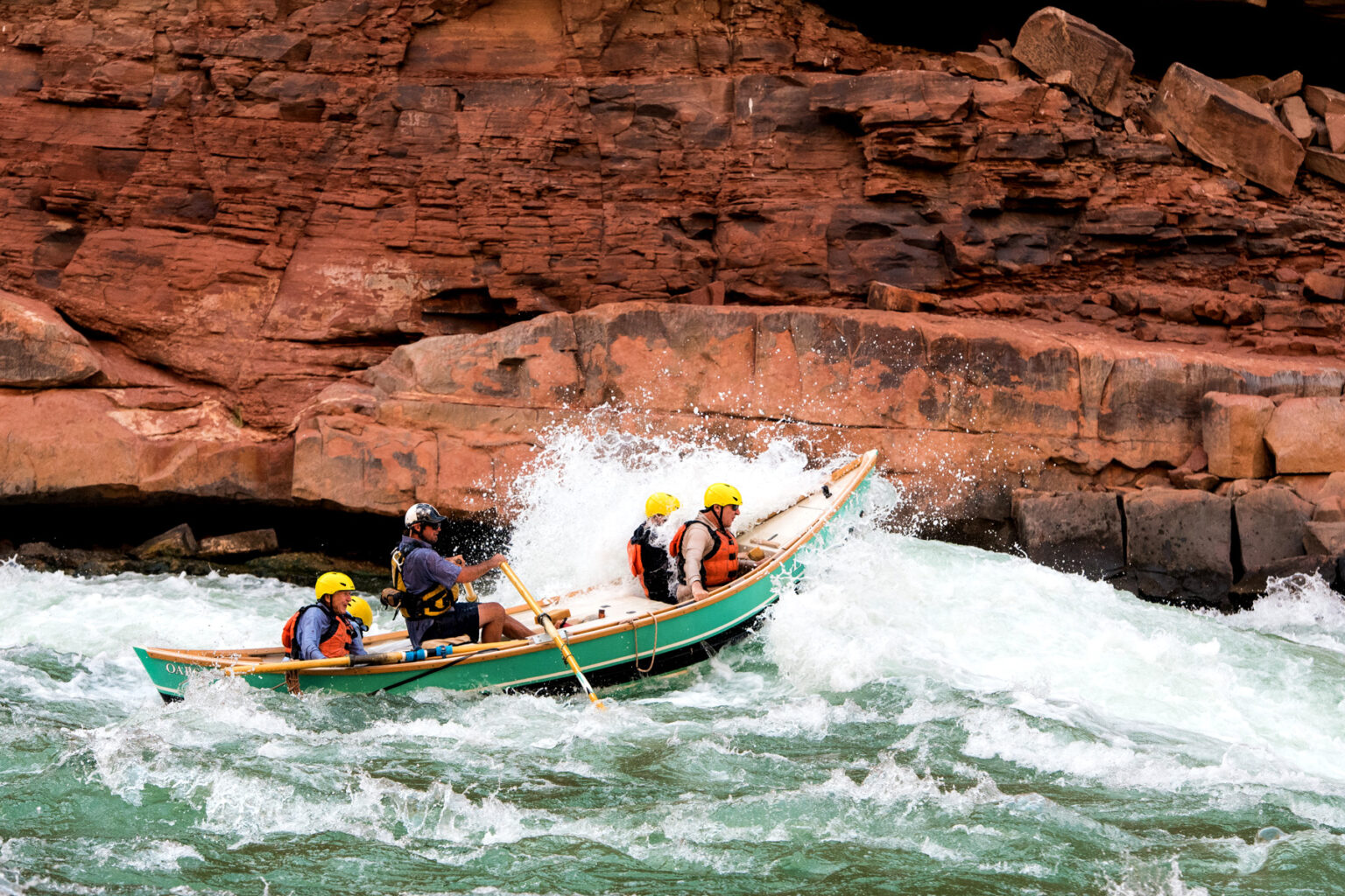OARS dory plows into large rapid as guests hang on in Colorado River through Grand Canyon