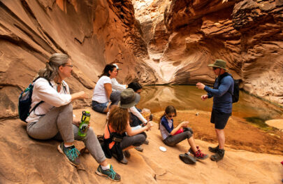 OARS guide talks to guests a the end of a side hike in Grand Canyon