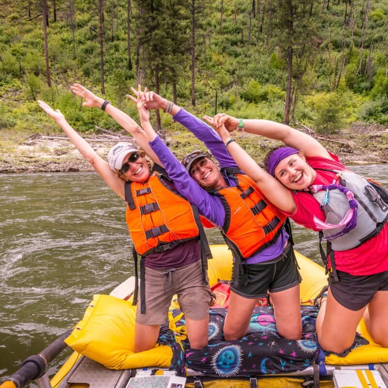 Three women posing as Salmon's on the boat on the Salmon River.