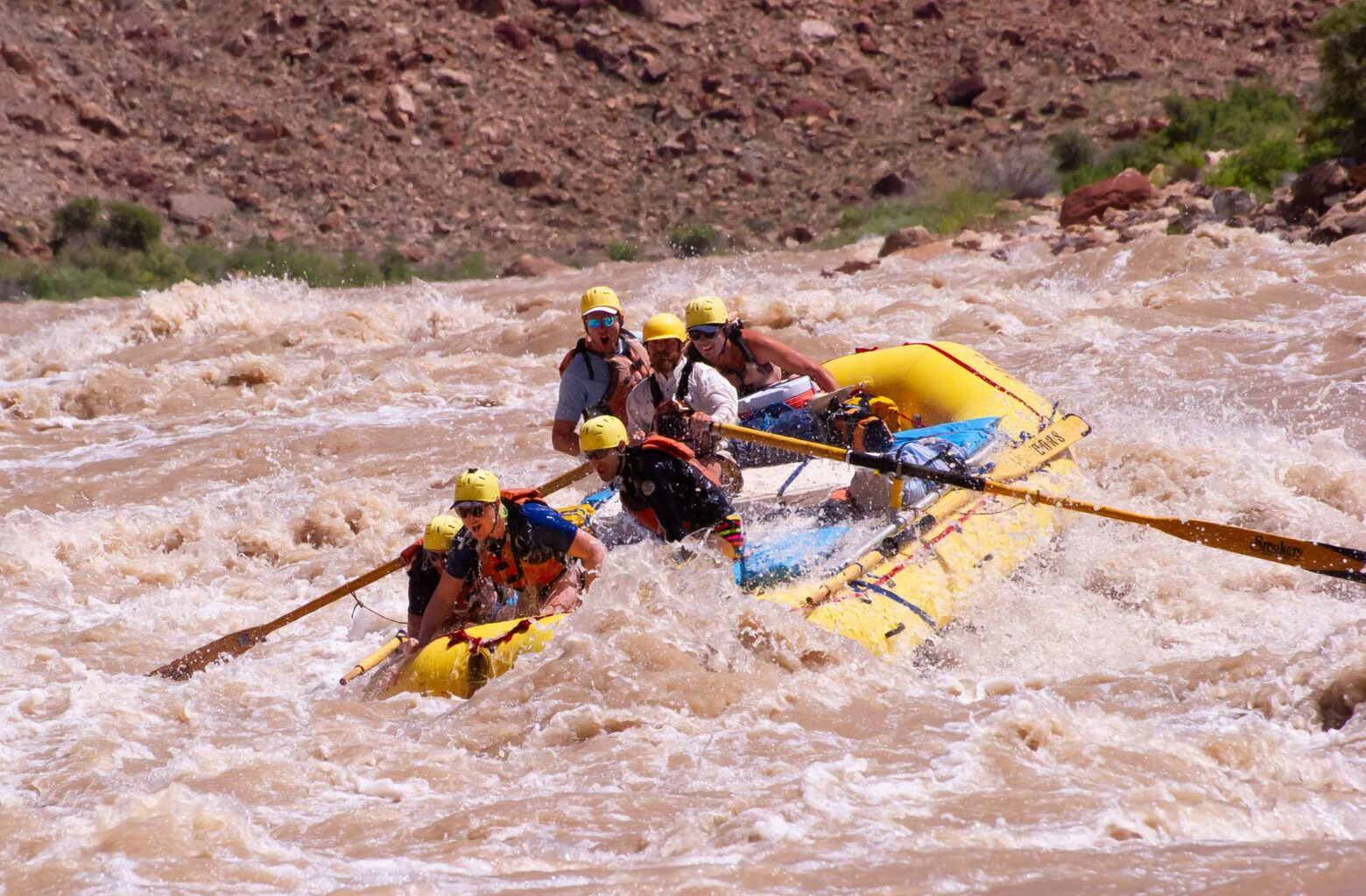 A group of people rafting through the Cataract River in Utah.
