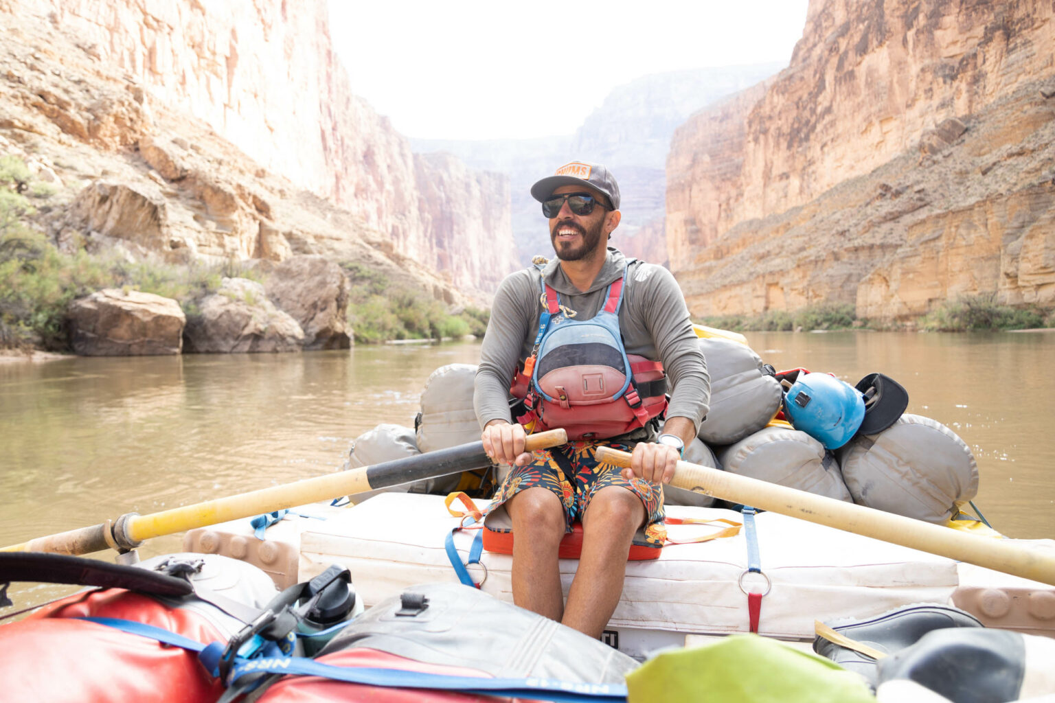 Guide rowing a raft through the Grand Canyon.