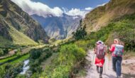 Two women hiking through a valley surrounded by mountains on Peru's Inca Trail to Machu Picchu.