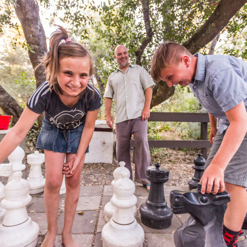 Family playing with the giant chess board.