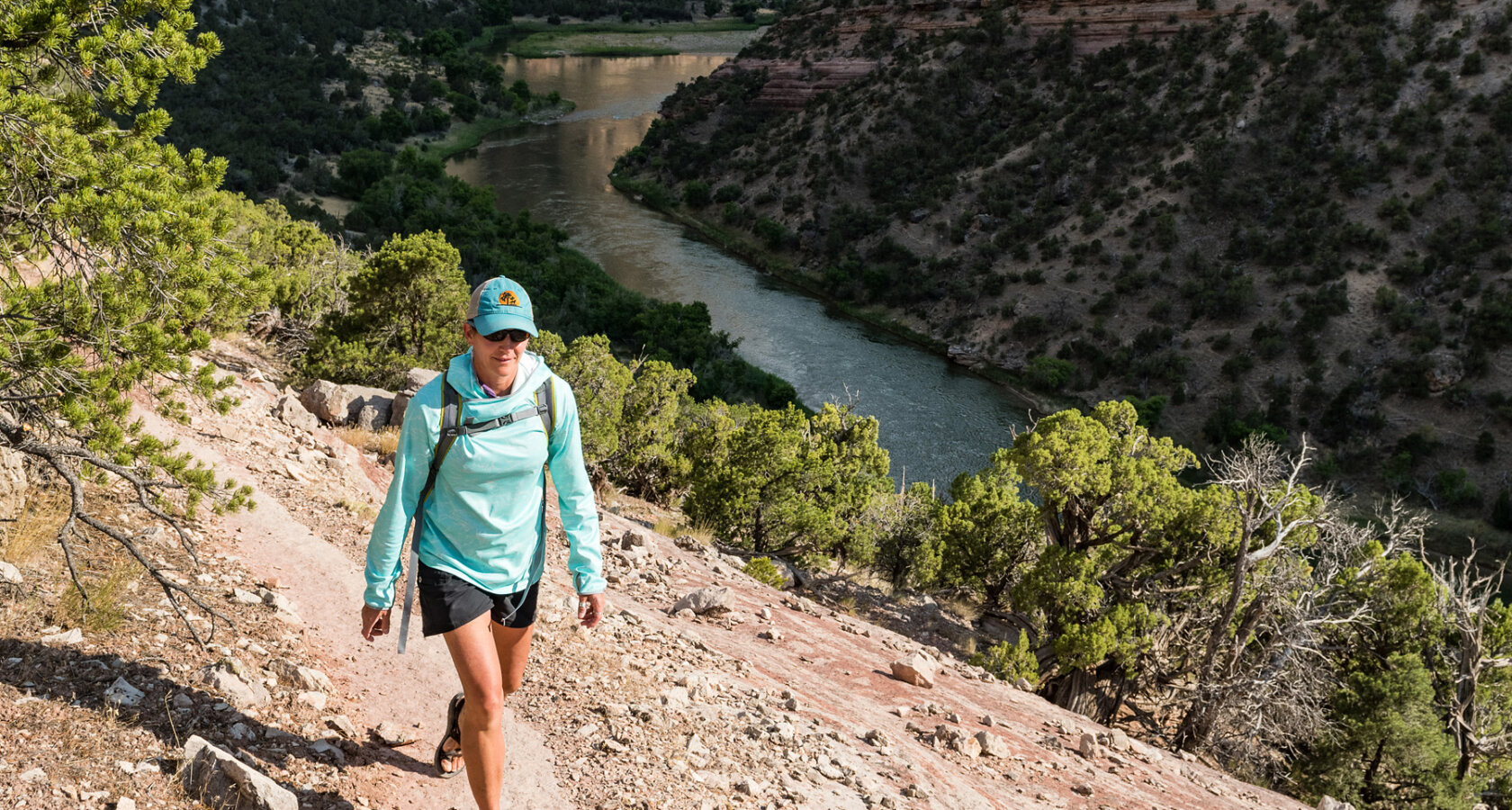 A hiker walks along a trail high above the Green River on a Gates of Lodore trip.
