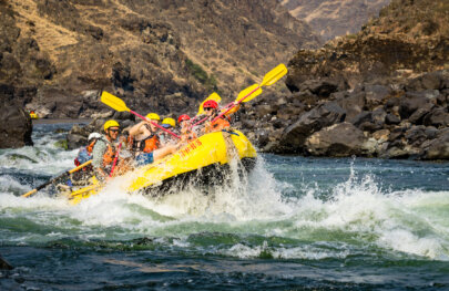 A raft full of paddlers plows through a rapid as they get splashed on the Lower Salmon River.