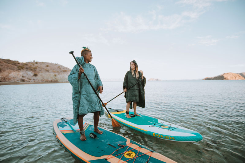 Two stand-up paddlers wearing Therm-a-rest Honcho Ponchos