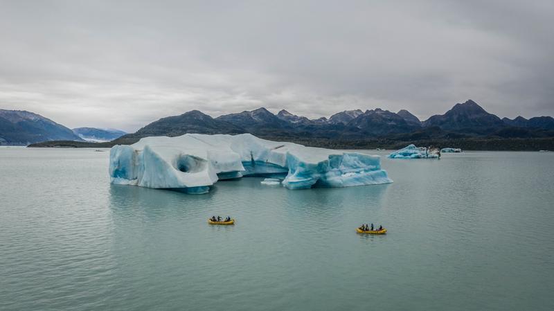 Rafting on Alaska's Tatshenshini River near an ice berg.