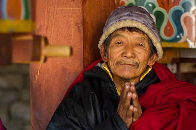 Local Bhutanese man, sitting at prayer wheel in Trongsa Dzong.