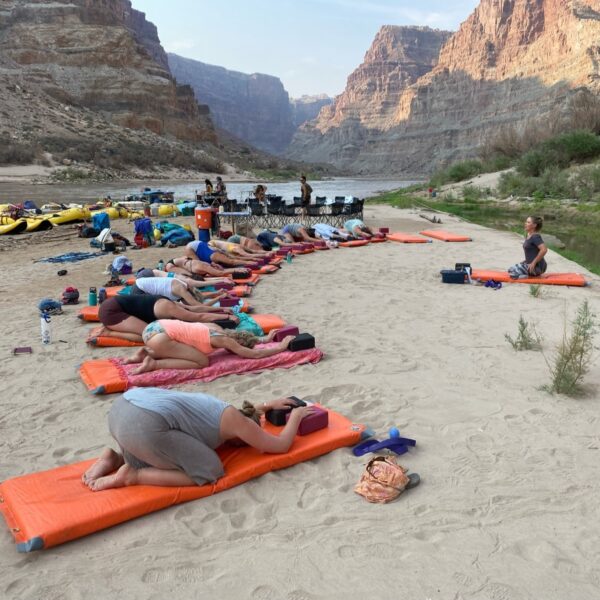 Group of people doing yoga on a beach along the Colorado River in Cataract Canyon