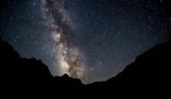 A vibrant Milky Way and starry sky above the outline of black canyon walls on an OARS river trip.