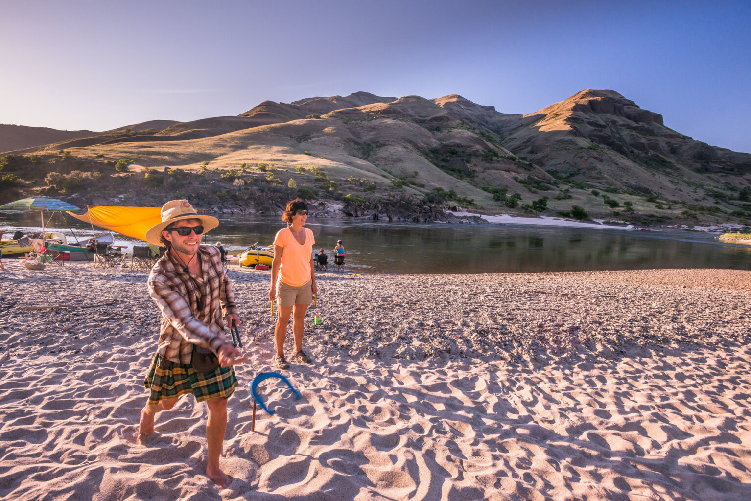 Two adults play horseshoes on a vast sandy beach along the Lower Salmon River in Idaho.