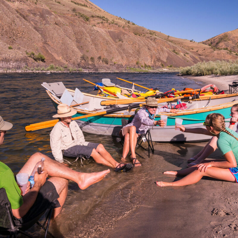 A group of adults lounge in the river on an OARS Lower Salmon River Craft Beer trip.