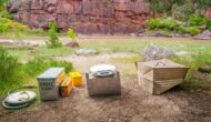 portable toilet sitting outside next to a river.