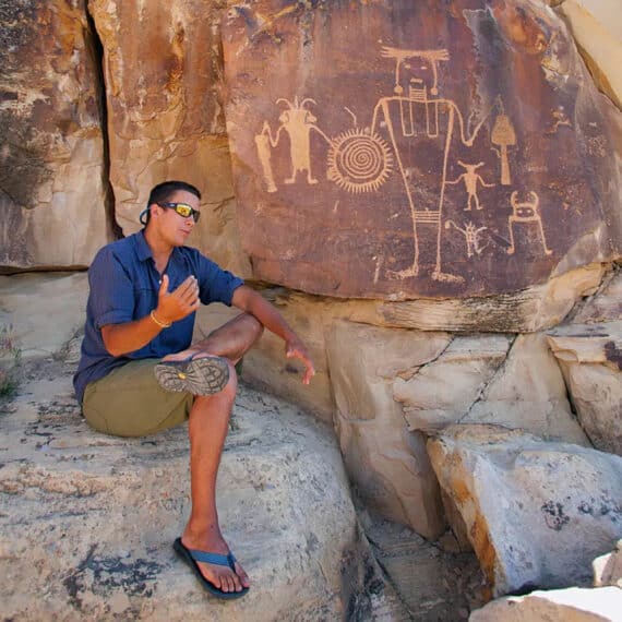 A guide talking about petroglyphs to the group.