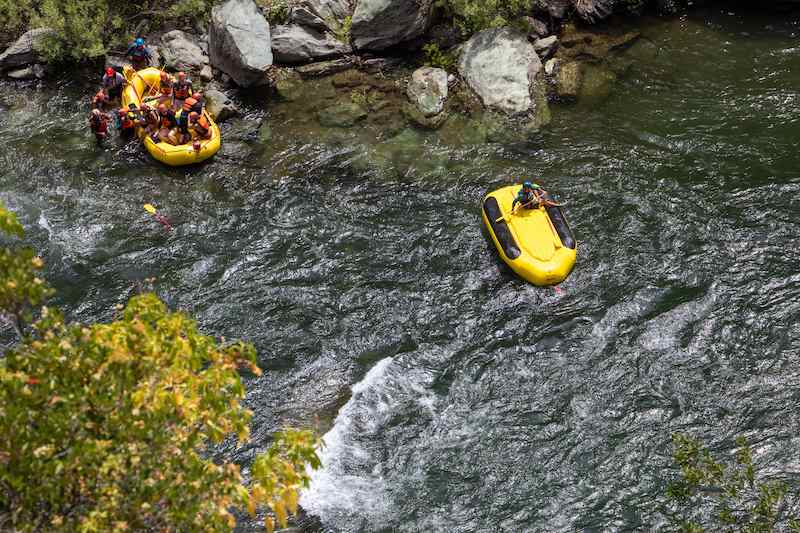 A raft guide rides an upside down raft during a training run on the Middle Fork of the American River.