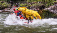 A yellow raft in mid-flip on the Tuolumne River trip in California as guests fall into the river