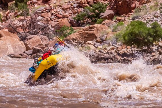 raft hitting a rapid on the river.