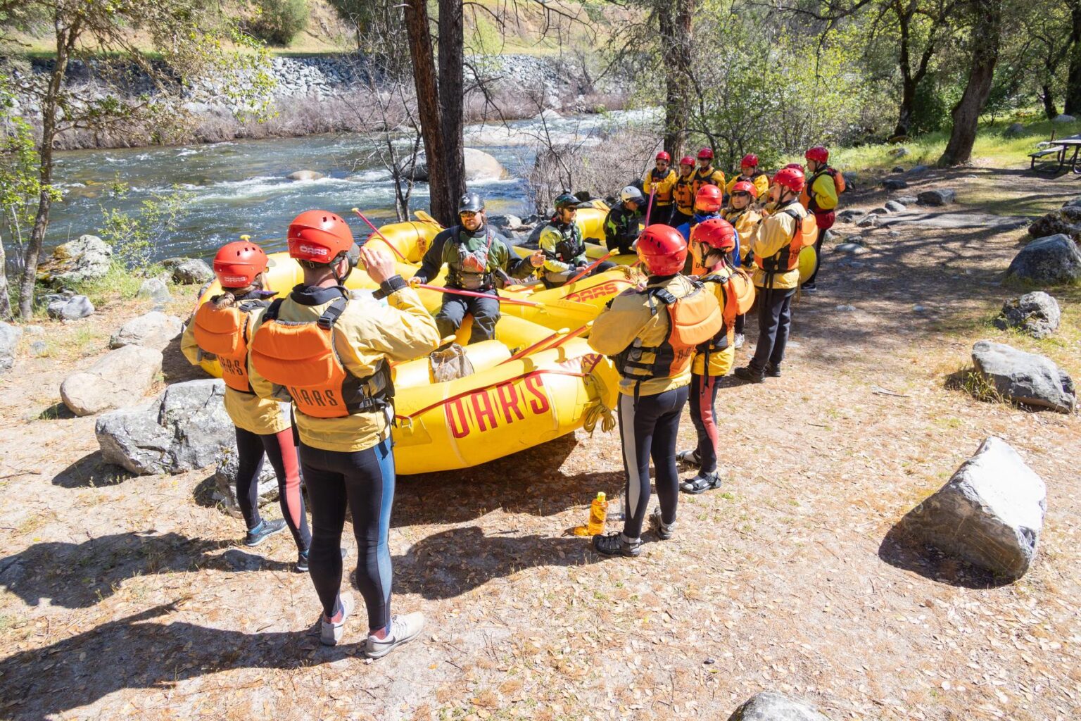 A group of rafters in wetsuits preparing to raft the Merced River in the spring