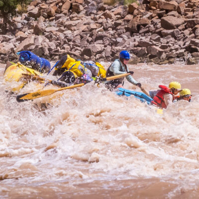 An OARS guide rows a raft through whitewater in Cataract Canyon in Utah
