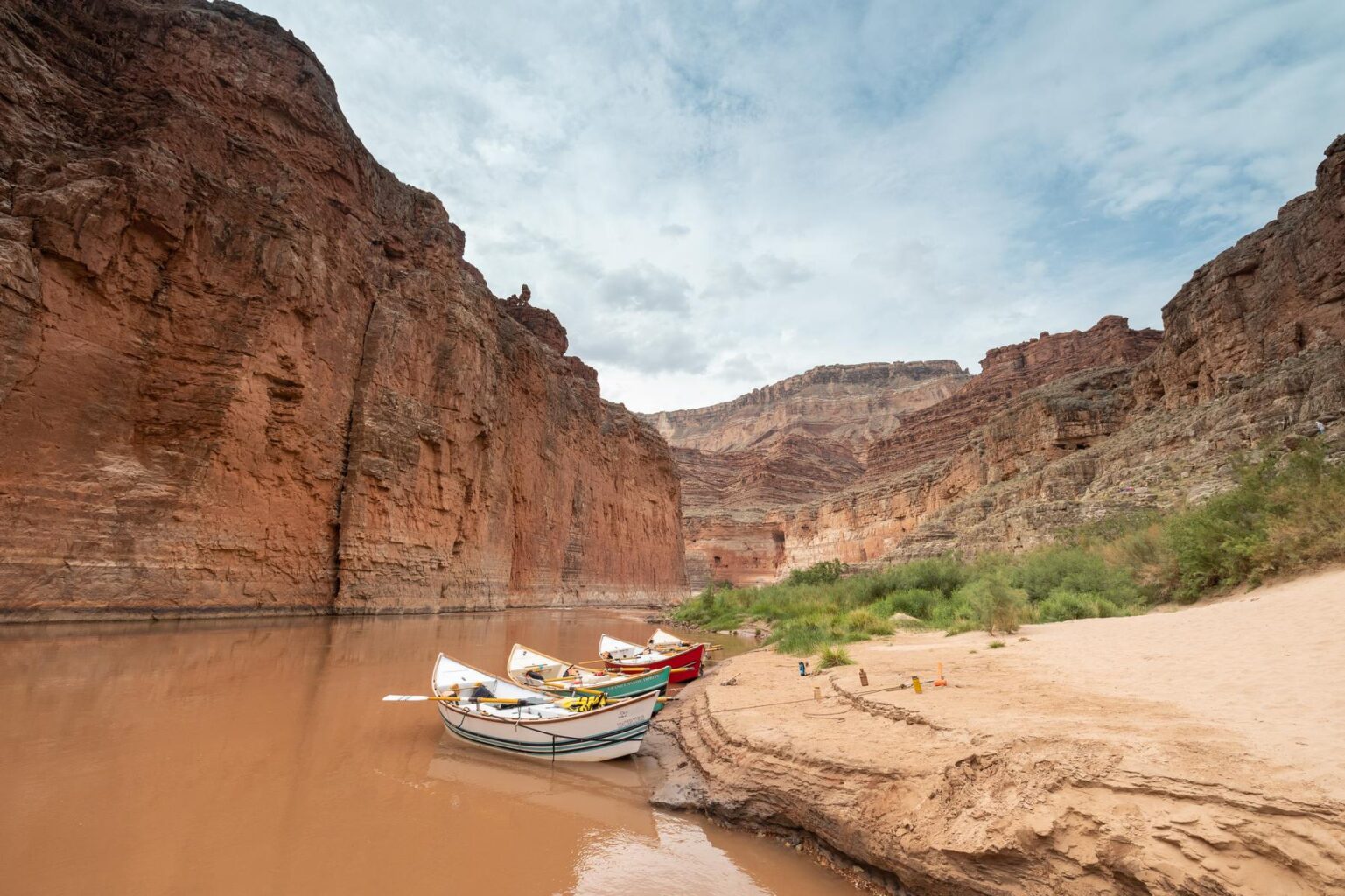 Four wooden dores line an eroded shoreline in Grand Canyon.