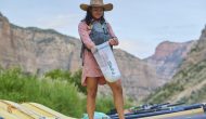 A woman packs a small dry bag during an OARS rafting trip