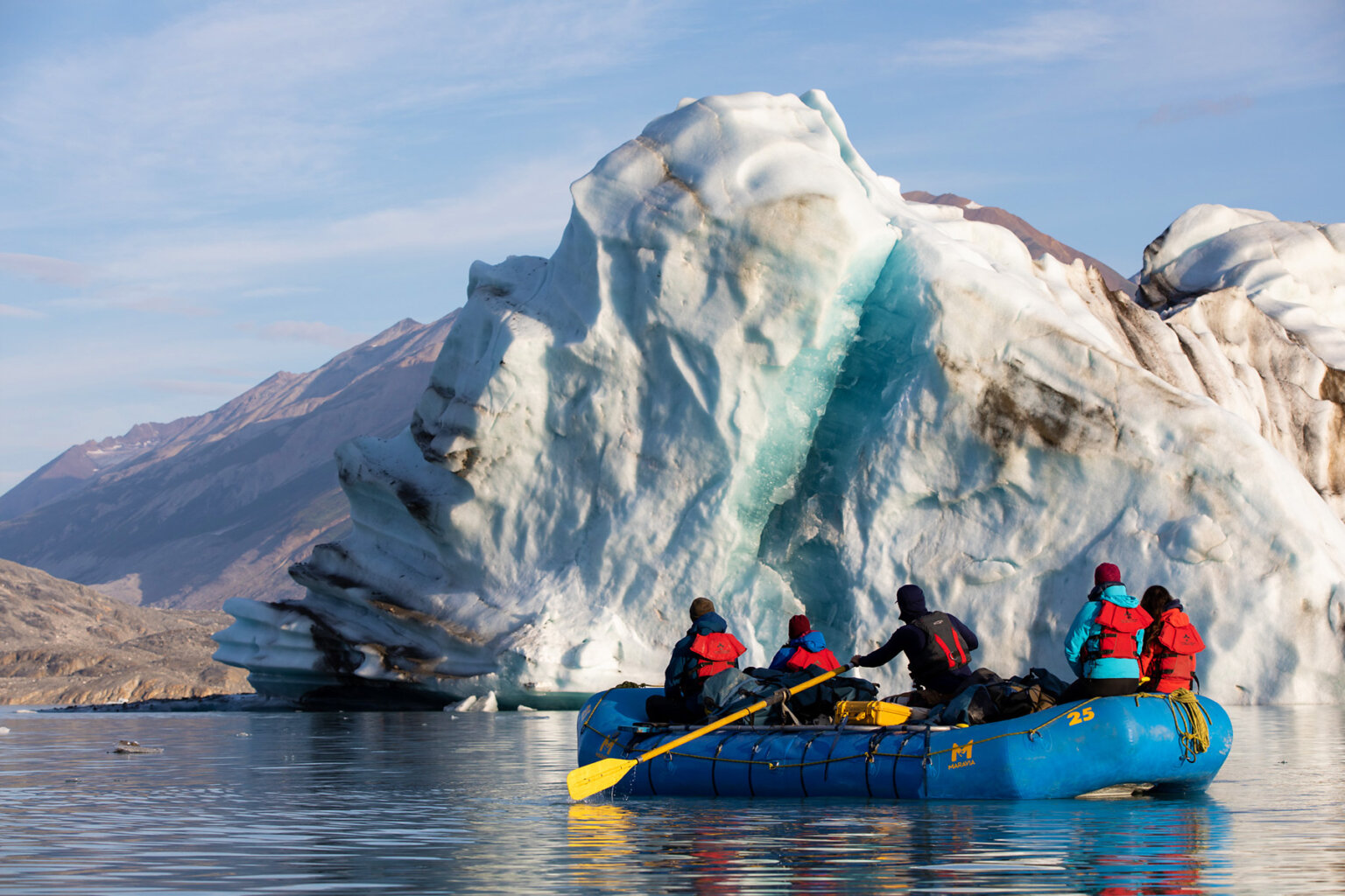 Rafters float past a massive icebert on the Alsek River