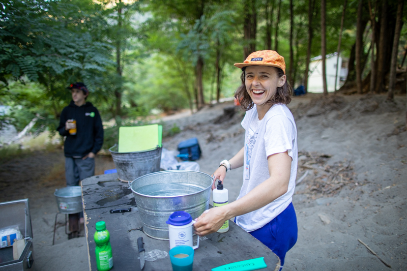 An OARS guide prepares the dish station on a Tuolumne River trip