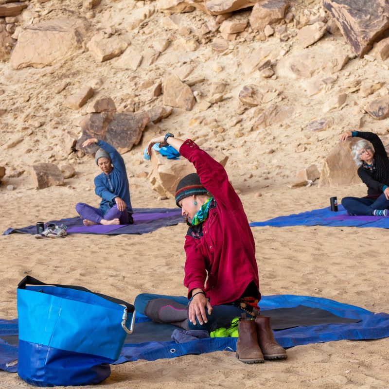 Mindfulness instructor Heidi Bourne leads a yoga session on a sandy beach on an OARS trip.