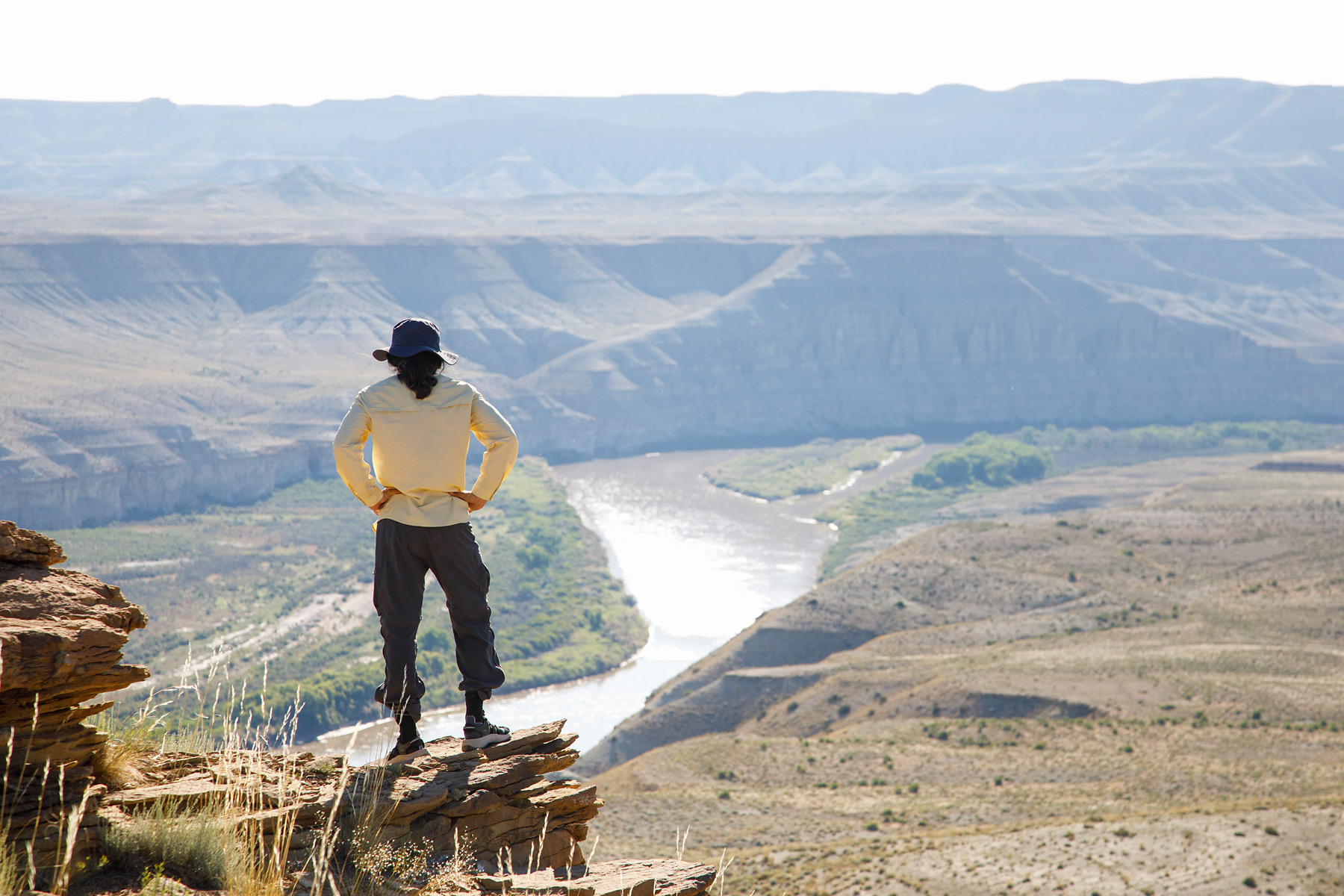 A hiker stands high above the Green River and takes in the view of Desolation Canyon in Utah.