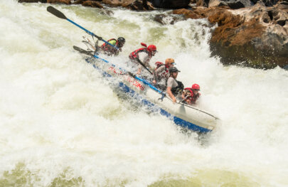 Paddlers hold on tight as their raft, steered by a guide on oars, veers downward in a massive rapid on the Zambezi River.