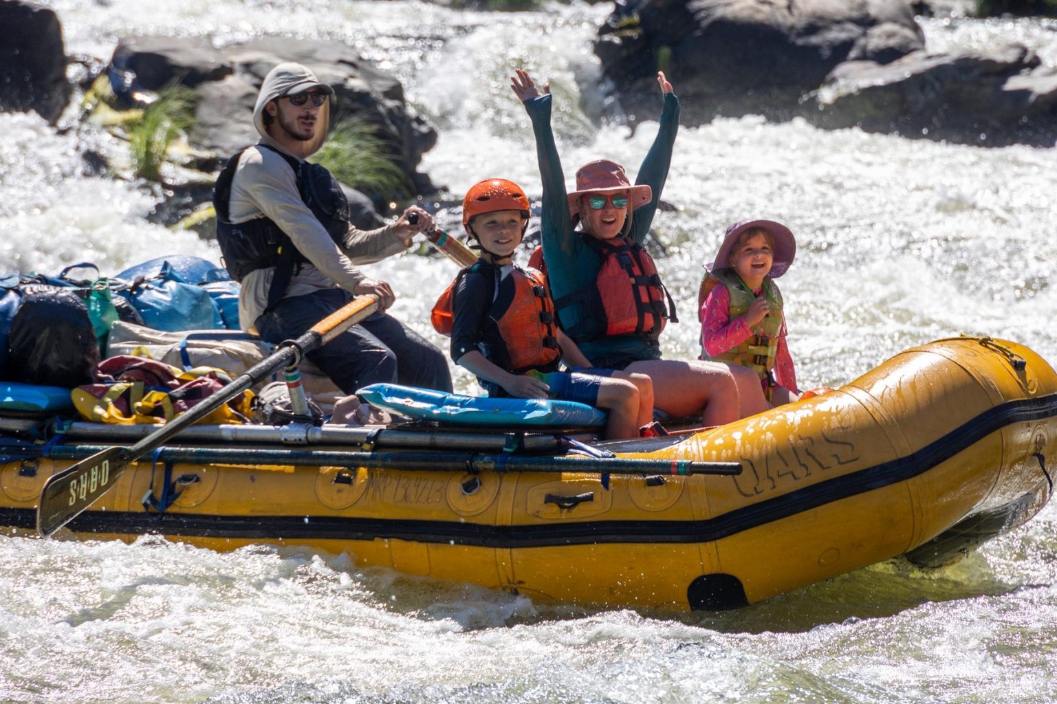 A family of rafters celebrates a rapid on the Klamath River in the summer of 2023