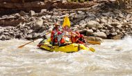 OARS guide Zack Sam celebrates with guests after running a rapid