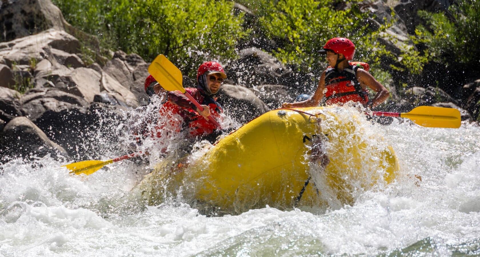A raft with OARS guide school participants splashes through a rapid on the South Fork of the American River