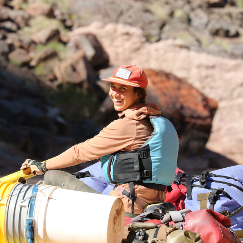 OARS Guide, Sarah Mallory, sits atop a baggage boat