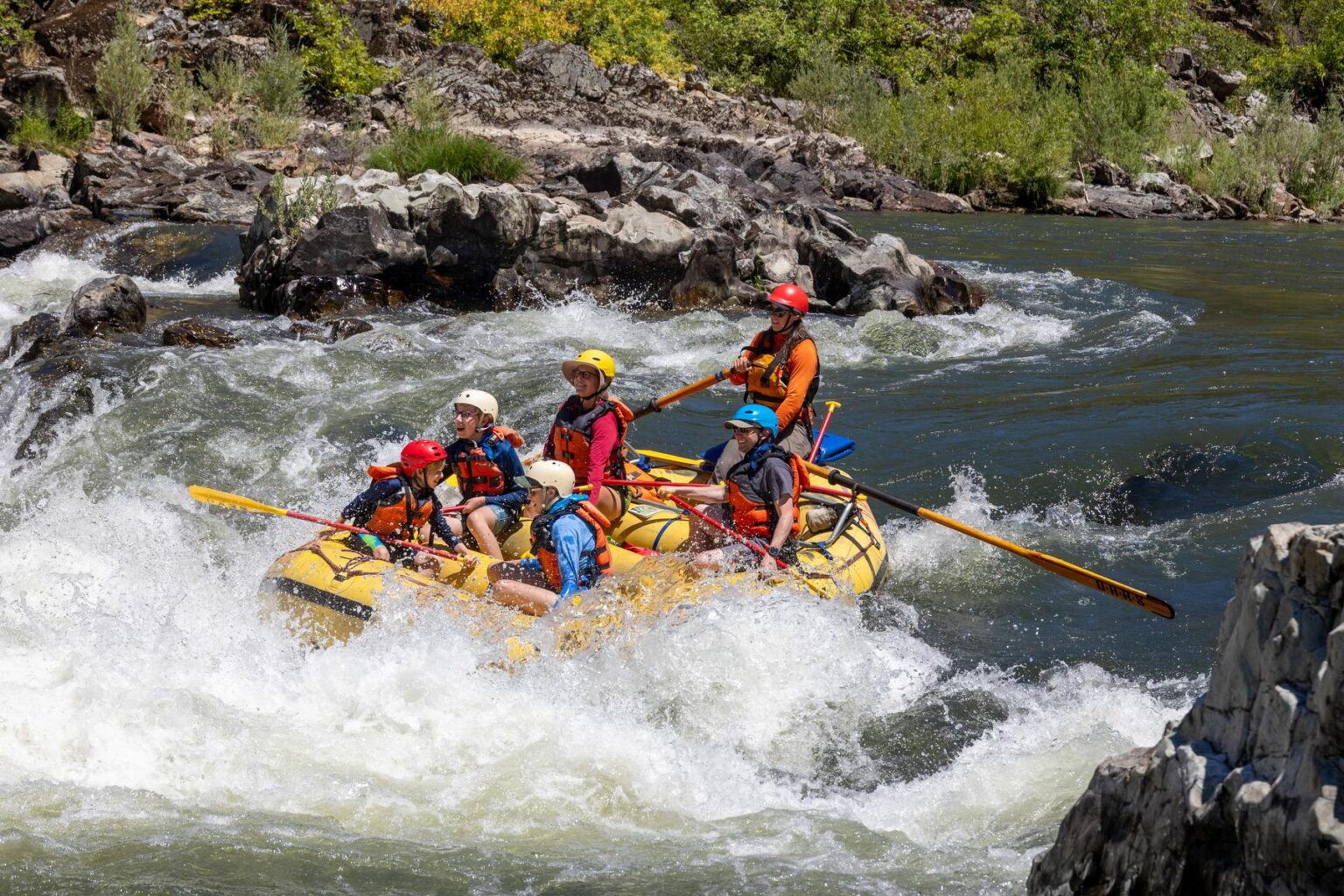 A guide rows an oar-assisted paddle raft through a splashy rapid on Oregon's Rogue River.
