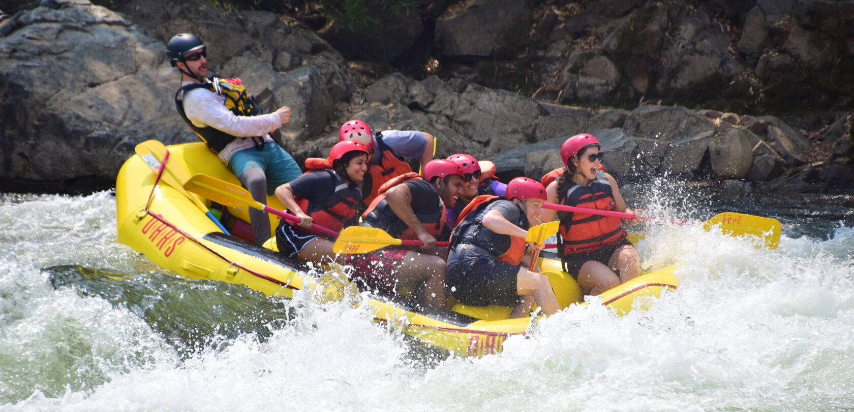 Group of adults rafting on the South Fork American River prepare for big splash