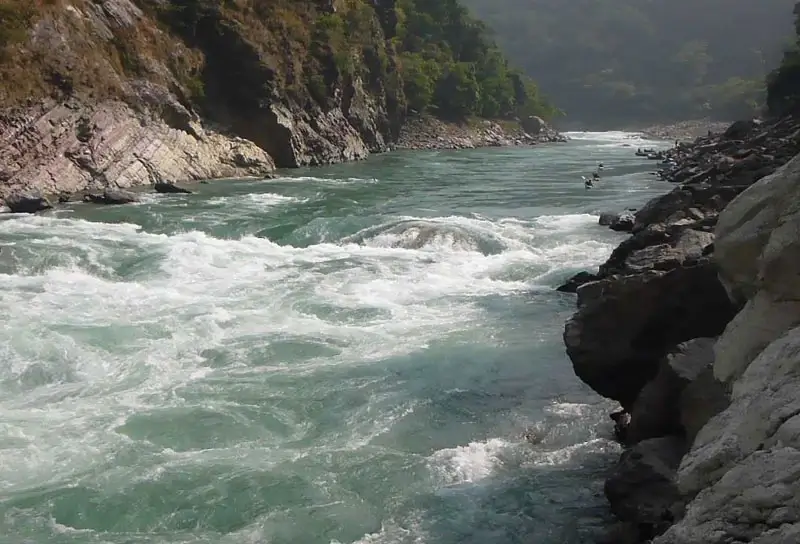 Three kayakers approach God's House Rapid on the Karnali River in Nepal.