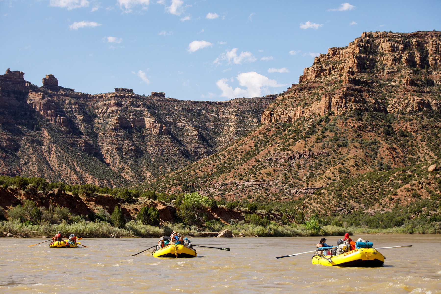 Three yellow rafts float down the Green River in Desolation Canyon, Utah.