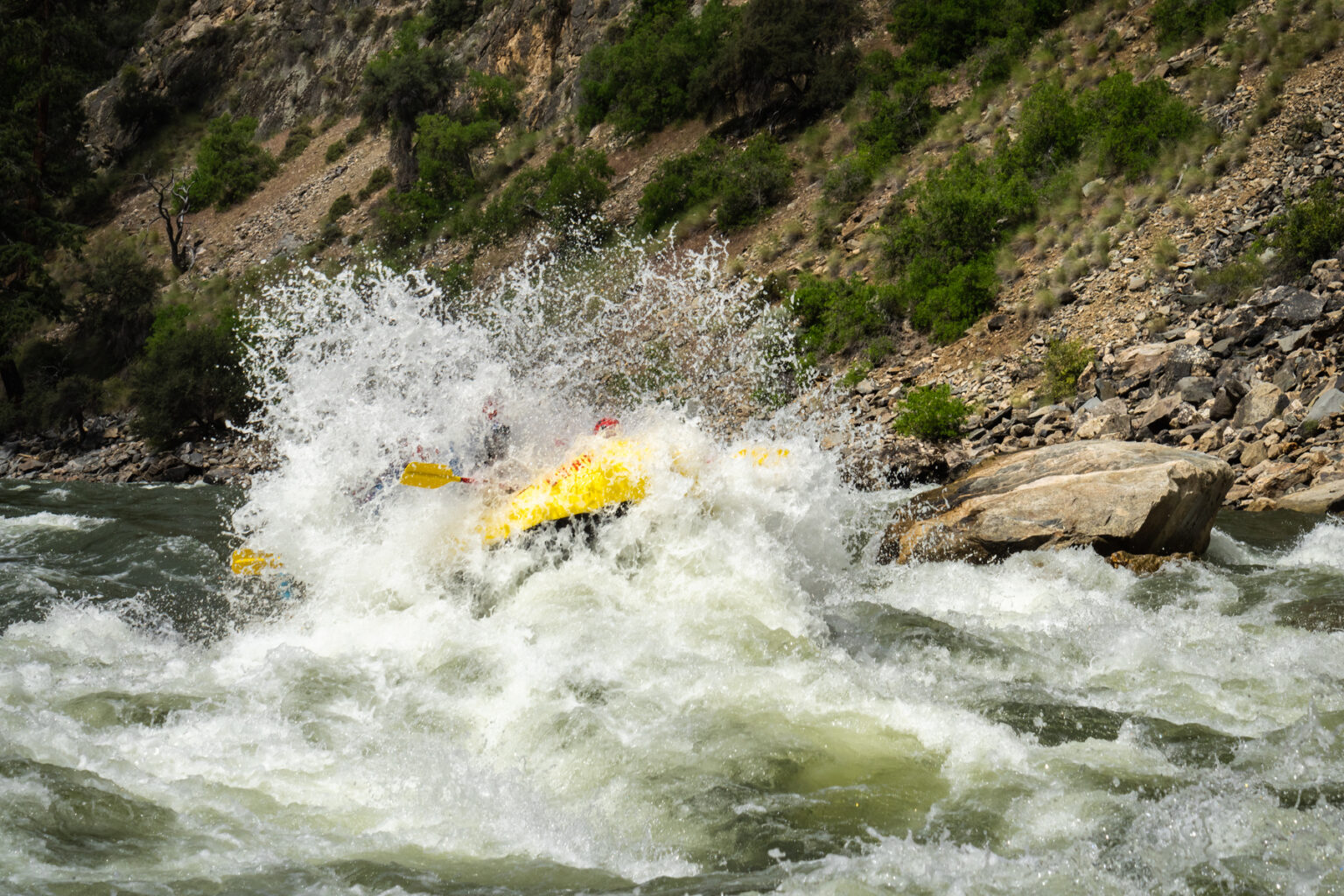 An OARS raft blasts through a rapid on the Middle Fork of the Salmon River in Idaho